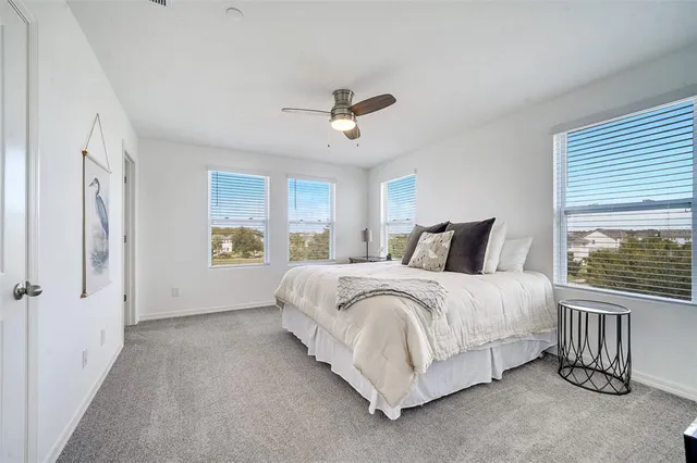 a spacious bedroom with a bed chandelier and a window