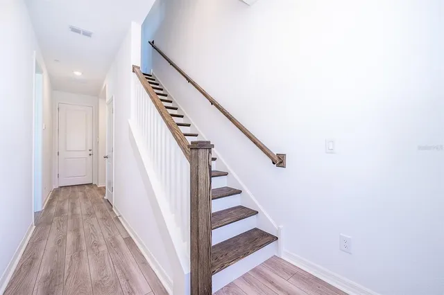a view of a hallway with wooden floor and entryway
