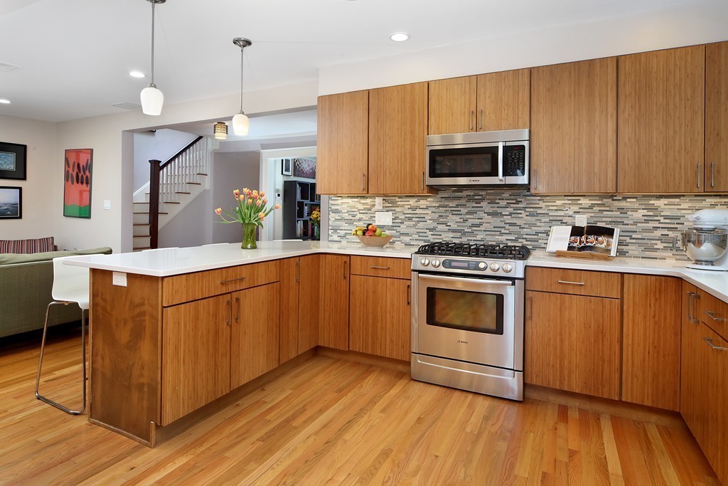 69 Winthrop Road, Unit 69 Brookline, MA 02445 - Photo 11 of 14 a kitchen with stainless steel appliances granite countertop wooden cabinets a sink a stove a refrigerator and island with wooden floor
