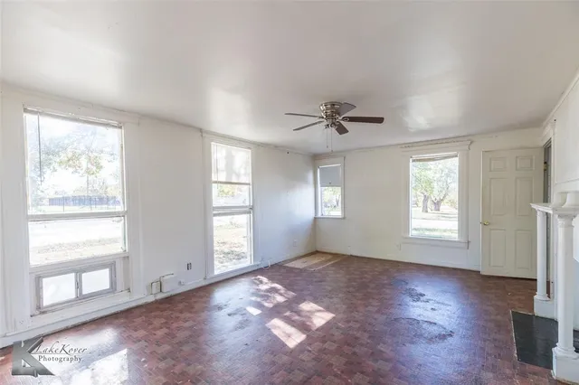 a view of empty room with cabinet and ceiling fan
