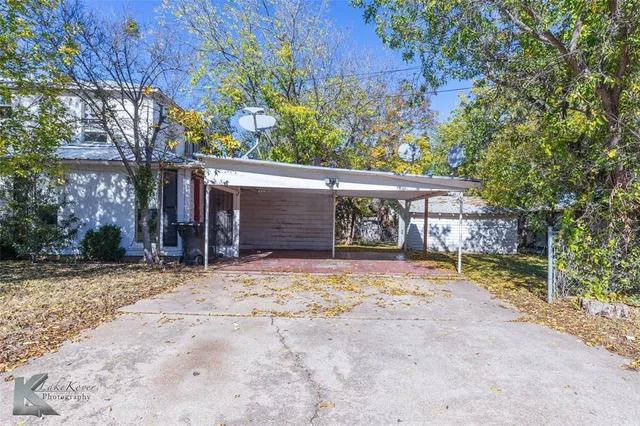 a view of a house with large trees and a tree