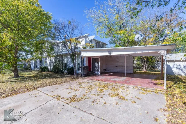 a view of a house with a tree in the yard