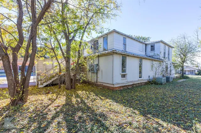 a view of a house with a yard and large tree