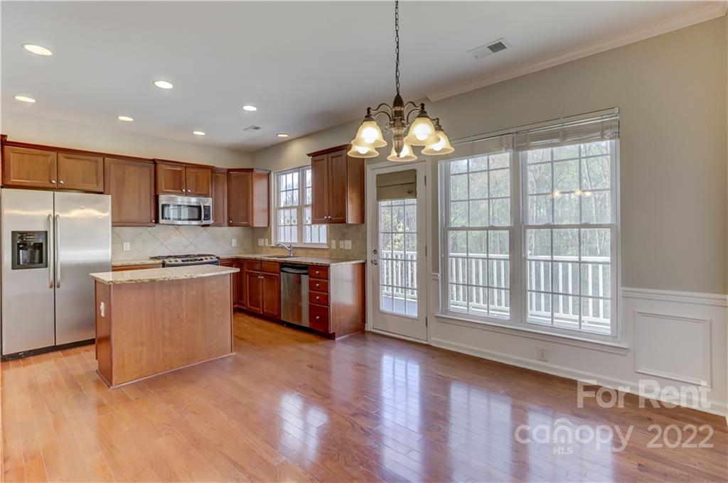 562 6th Baxter Crossing Fort Mill, SC 29708 - Photo 16 of 48 a open kitchen with stainless steel appliances granite countertop a stove a sink dishwasher a refrigerator and white cabinets with wooden floor