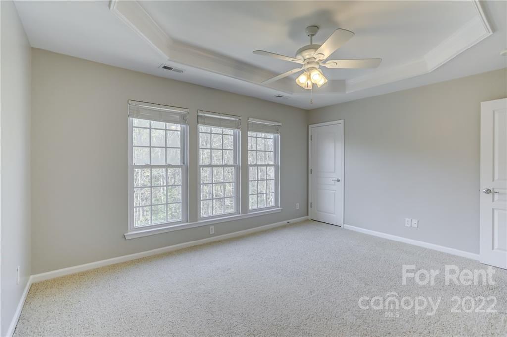 562 6th Baxter Crossing Fort Mill, SC 29708 - Photo 21 of 48 an empty room with chandelier fan and windows