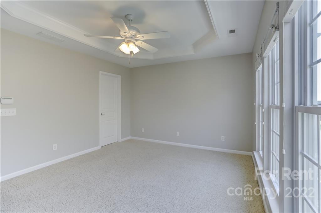 562 6th Baxter Crossing Fort Mill, SC 29708 - Photo 23 of 48 an empty room with a chandelier fan and windows