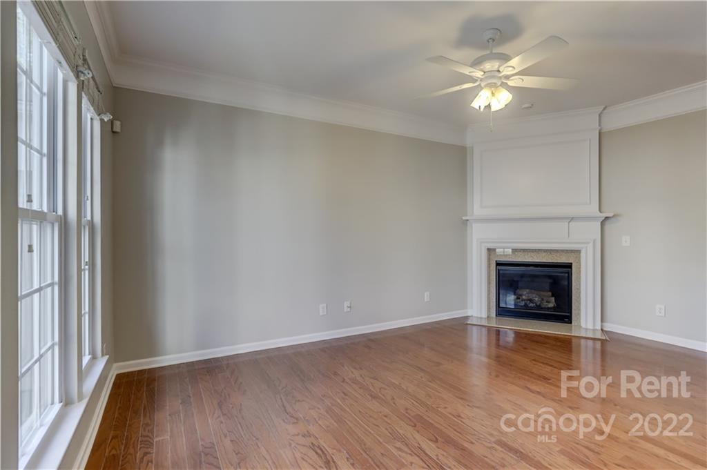 562 6th Baxter Crossing Fort Mill, SC 29708 - Photo 7 of 48 an empty room with wooden floor fireplace and window