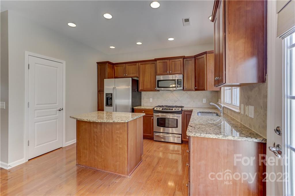 562 6th Baxter Crossing Fort Mill, SC 29708 - Photo 9 of 48 a kitchen with stainless steel appliances granite countertop wooden cabinets a stove top oven a sink and dishwasher