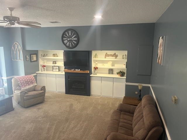 1347 Becton William Road Ripley, TN 38063 - Photo 13 of 24 Living room with a textured ceiling, ceiling fan, carpet, and a fireplace