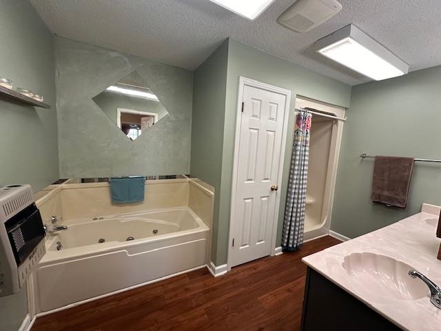 1347 Becton William Road Ripley, TN 38063 - Photo 17 of 24 Full bath featuring a jetted tub, double vanity, heating unit, a textured ceiling, and dark wood finished floors