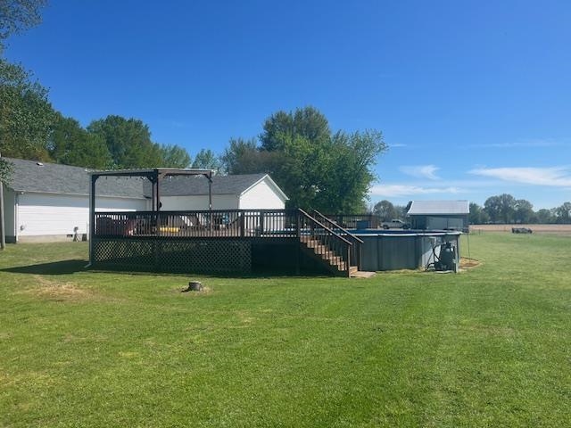1347 Becton William Road Ripley, TN 38063 - Photo 10 of 24 View of grassy yard featuring a wooden deck and an outdoor pool