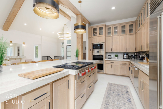 1188 South Old Trappers Loop Road Huntsville, UT 84317 - Photo 28 of 92 Gourmet kitchen featuring a large central island with a built-in gas range, light wood cabinetry, stone countertops, stainless steel appliances, and a tiled backsplash