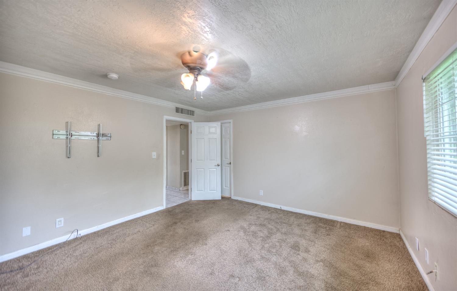 2170 Moir Drive Sanger, CA 93657 - Photo 11 of 22 an empty room with windows and fan