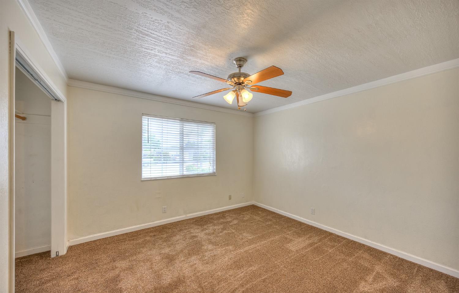 2170 Moir Drive Sanger, CA 93657 - Photo 13 of 22 an empty room with a window and a ceiling fan