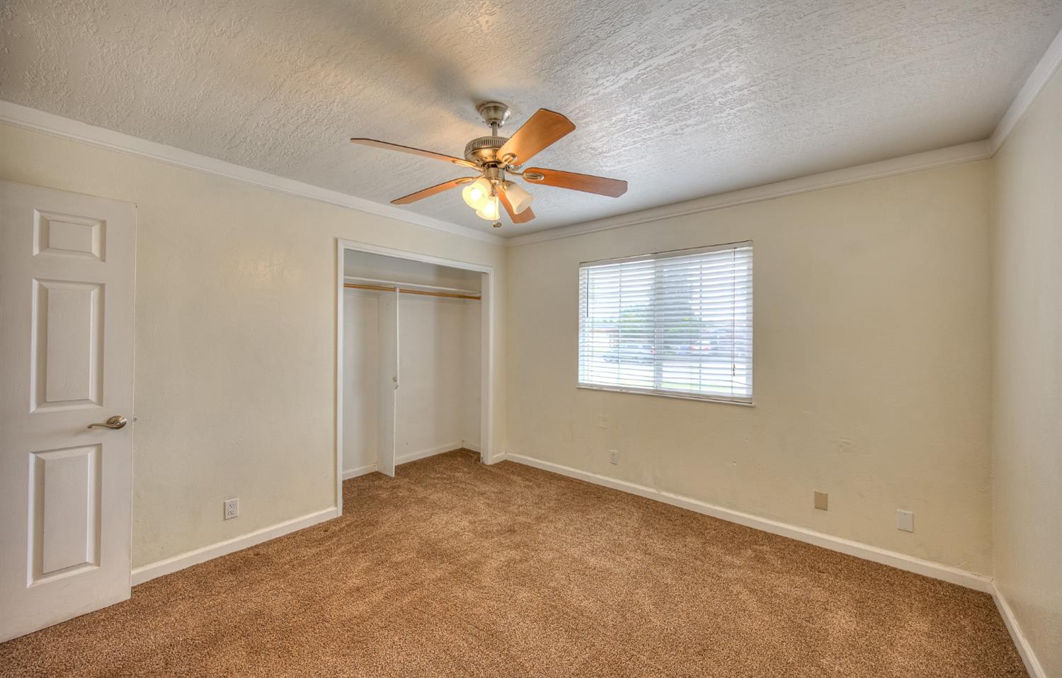 2170 Moir Drive Sanger, CA 93657 - Photo 14 of 22 an empty room with windows and fan chandelier fan
