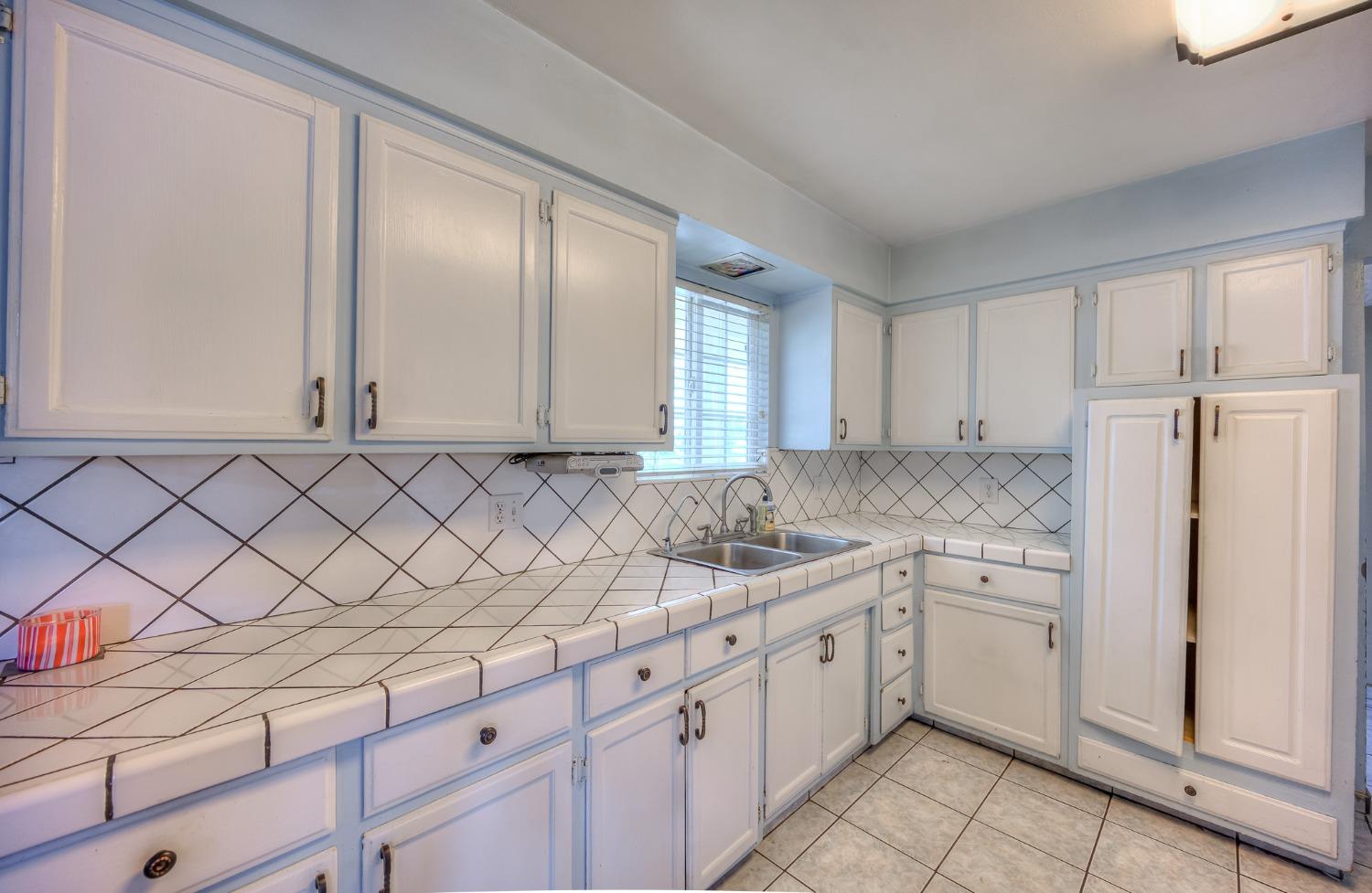 2170 Moir Drive Sanger, CA 93657 - Photo 6 of 22 a kitchen with granite countertop white cabinets and white appliances