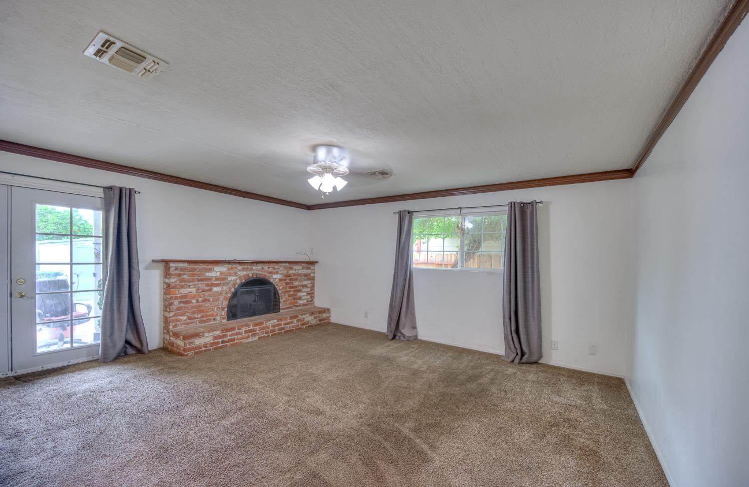 2170 Moir Drive Sanger, CA 93657 - Photo 8 of 22 a view of an empty room with a fireplace and a window