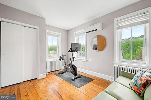 a view of a bedroom with wooden floor and windows