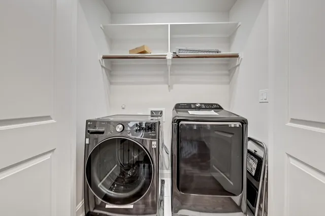 a utility room with dryer washer and empty racks