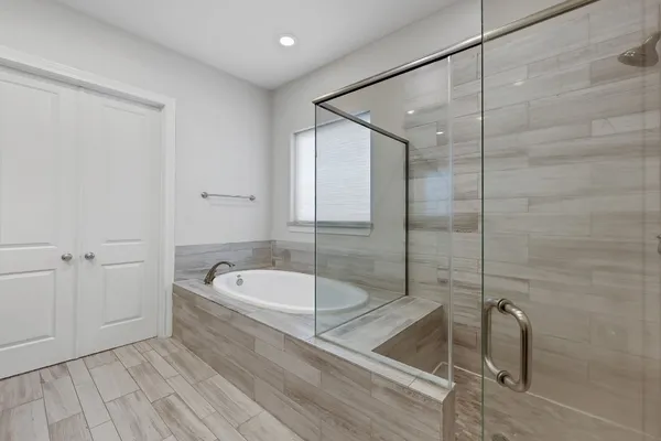 a bathroom with a tub a toilet and a shower