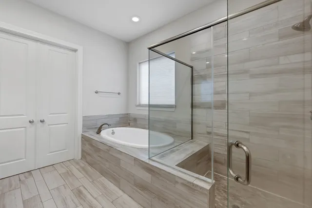 a bathroom with a tub a toilet and a shower