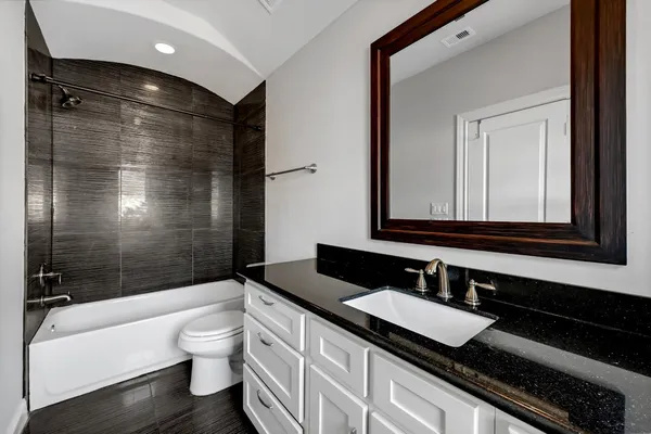 a bathroom with a granite countertop sink toilet and shower