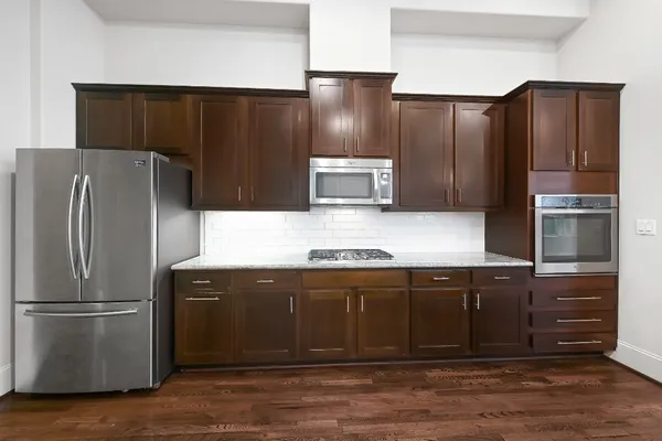 a kitchen with stainless steel appliances granite countertop a refrigerator and a stove