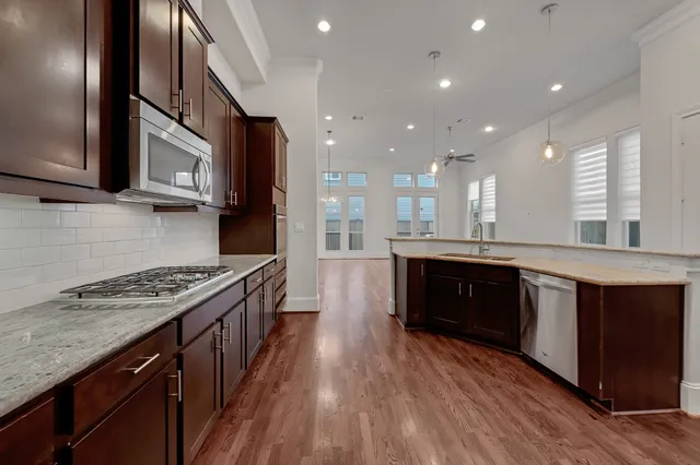 a kitchen with stainless steel appliances granite countertop a stove a sink and a refrigerator