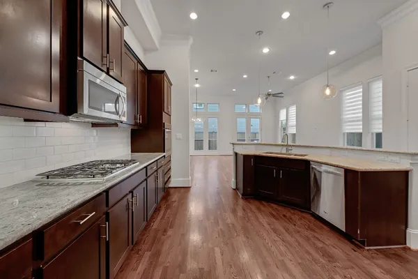 a kitchen with stainless steel appliances granite countertop a stove a sink and a refrigerator