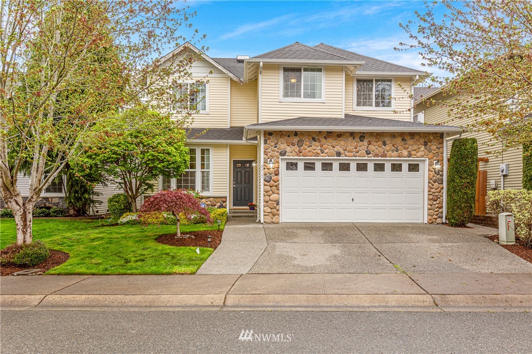 4313 147th Place Southeast Bothell, WA 98012 - Photo 2 of 29 a front view of a house with a garden and garage