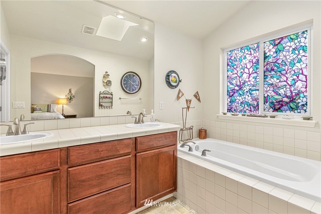 4313 147th Place Southeast Bothell, WA 98012 - Photo 19 of 29 a bathroom with a sinks a large mirror a bathtub and a shower