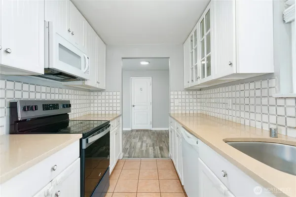 a kitchen with a sink stove top oven and cabinets