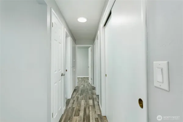 a view of a hallway with a white door and a wooden floor