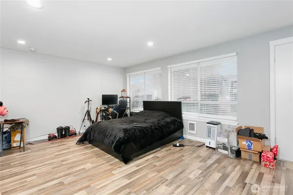 a spacious bedroom with a bed and a wooden floor