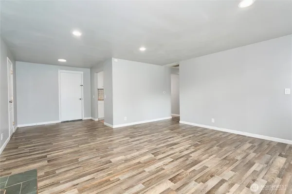 a view of an empty room with wooden floor