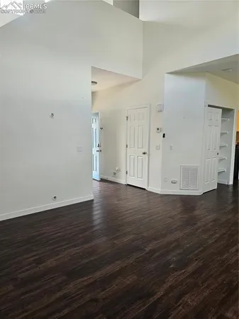 a view of a room with wooden floor and a ceiling fan
