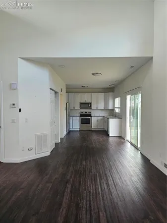 a kitchen with a refrigerator stove and wooden cabinets