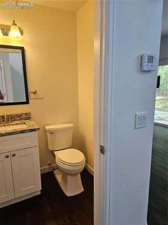 a bathroom with a granite countertop sink toilet and mirror