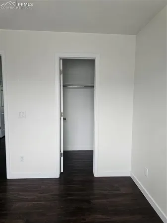 a view of small space with wooden floor and fan