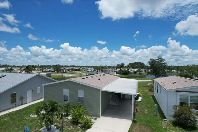 a view of a lake with a table and chairs next to a yard