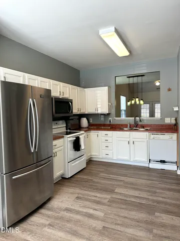 a kitchen with stainless steel appliances kitchen island granite countertop a stove a sink and a refrigerator