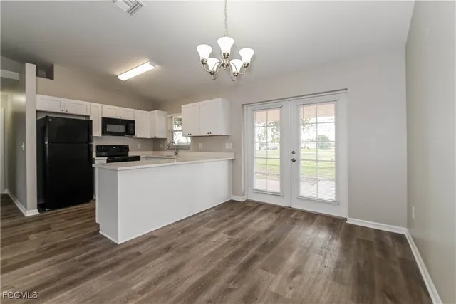 a kitchen with stainless steel appliances granite countertop a refrigerator a sink dishwasher a stove with wooden cabinets and floor