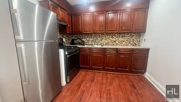 a kitchen with stainless steel appliances granite countertop wooden cabinets and a refrigerator