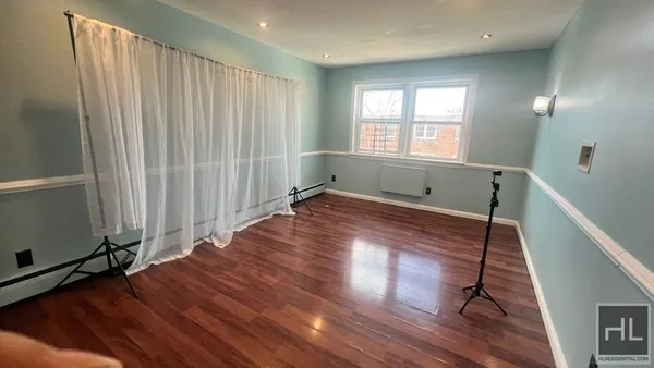a view of a room with wooden floor and window
