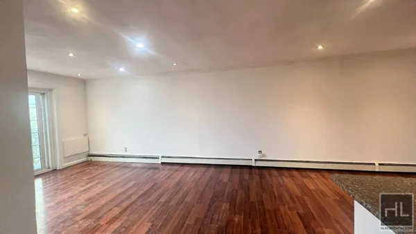 a view of a room with wooden floor and white walls