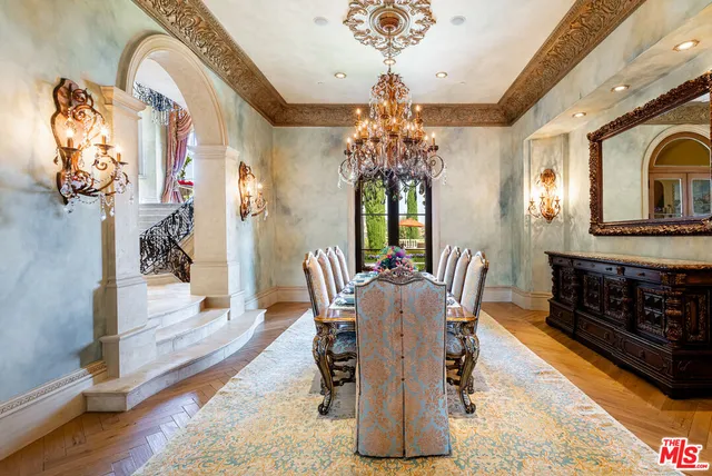 a dining room with furniture a chandelier and wooden floor