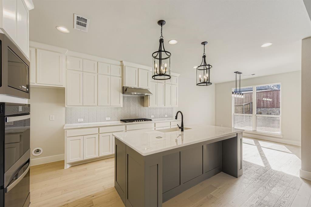 4446 Timberdrift Street Midlothian, TX 76065 - Photo 11 of 28 a kitchen that has a sink and a stove in it