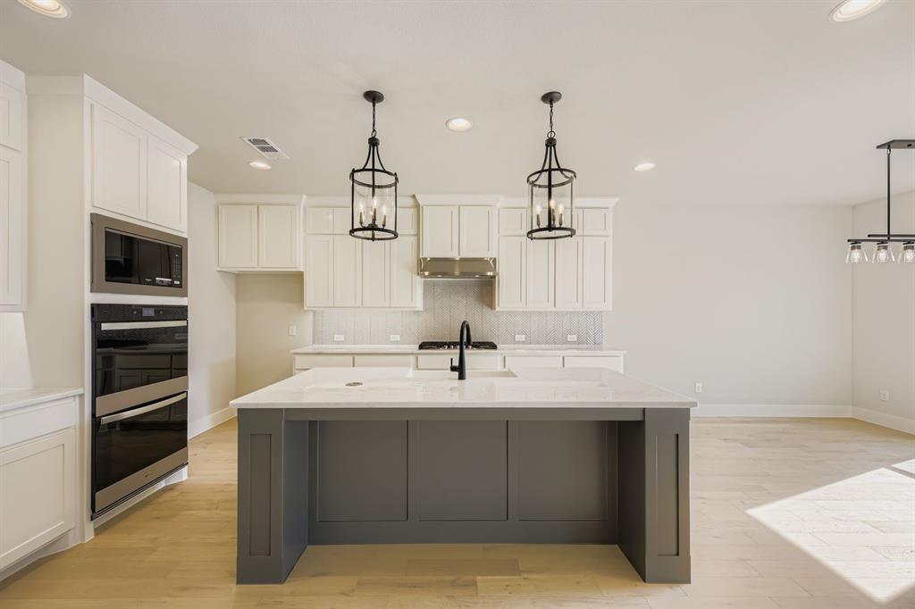 4446 Timberdrift Street Midlothian, TX 76065 - Photo 12 of 28 a kitchen with kitchen island a sink stainless steel appliances and cabinets