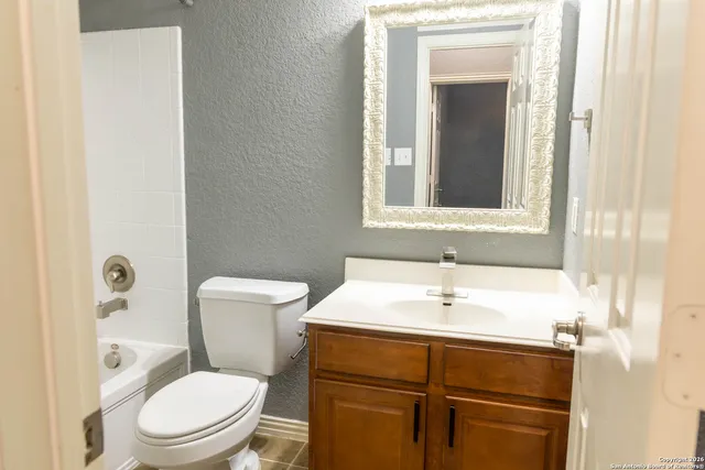a bathroom with a toilet sink and mirror