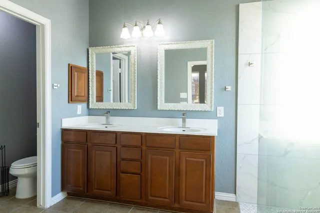 a bathroom with a toilet sink and mirror